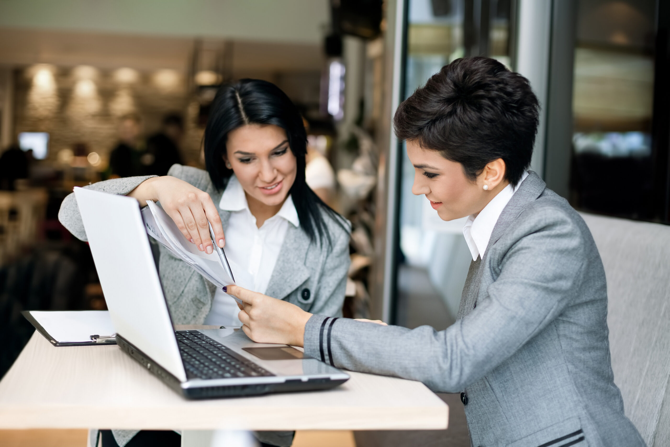 two business women talking over a contract